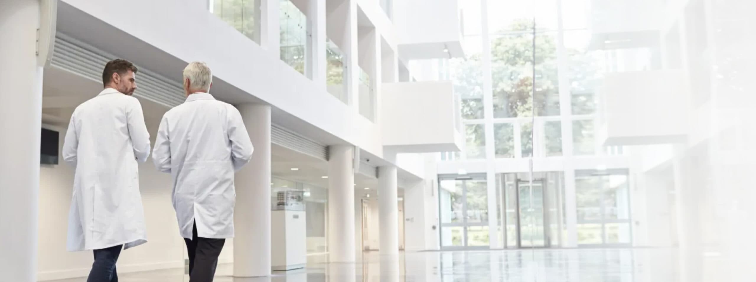 Photo of two male doctors walking toward the exit of a hospital