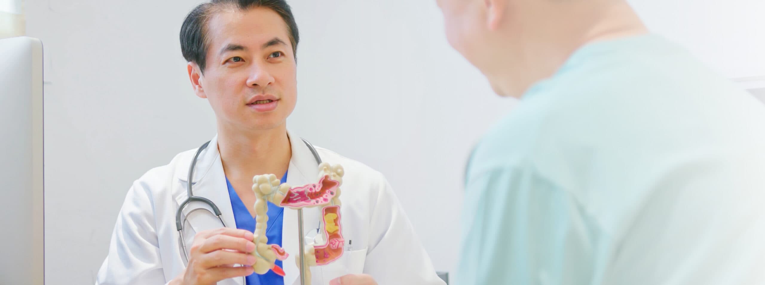 Photo of a doctor explaining the anatomy of the colon to a patient