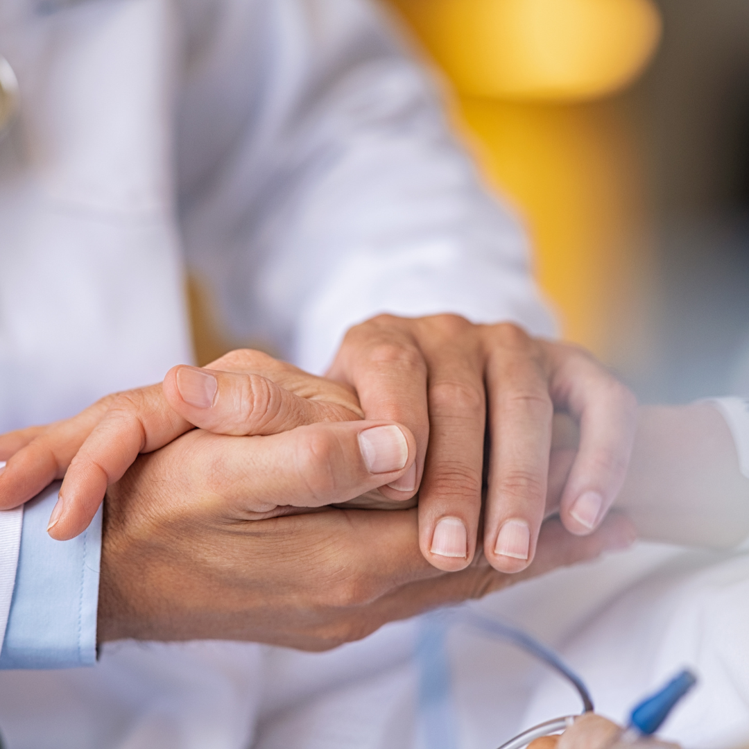coronis health close up of healthcare worker holding patient's hand