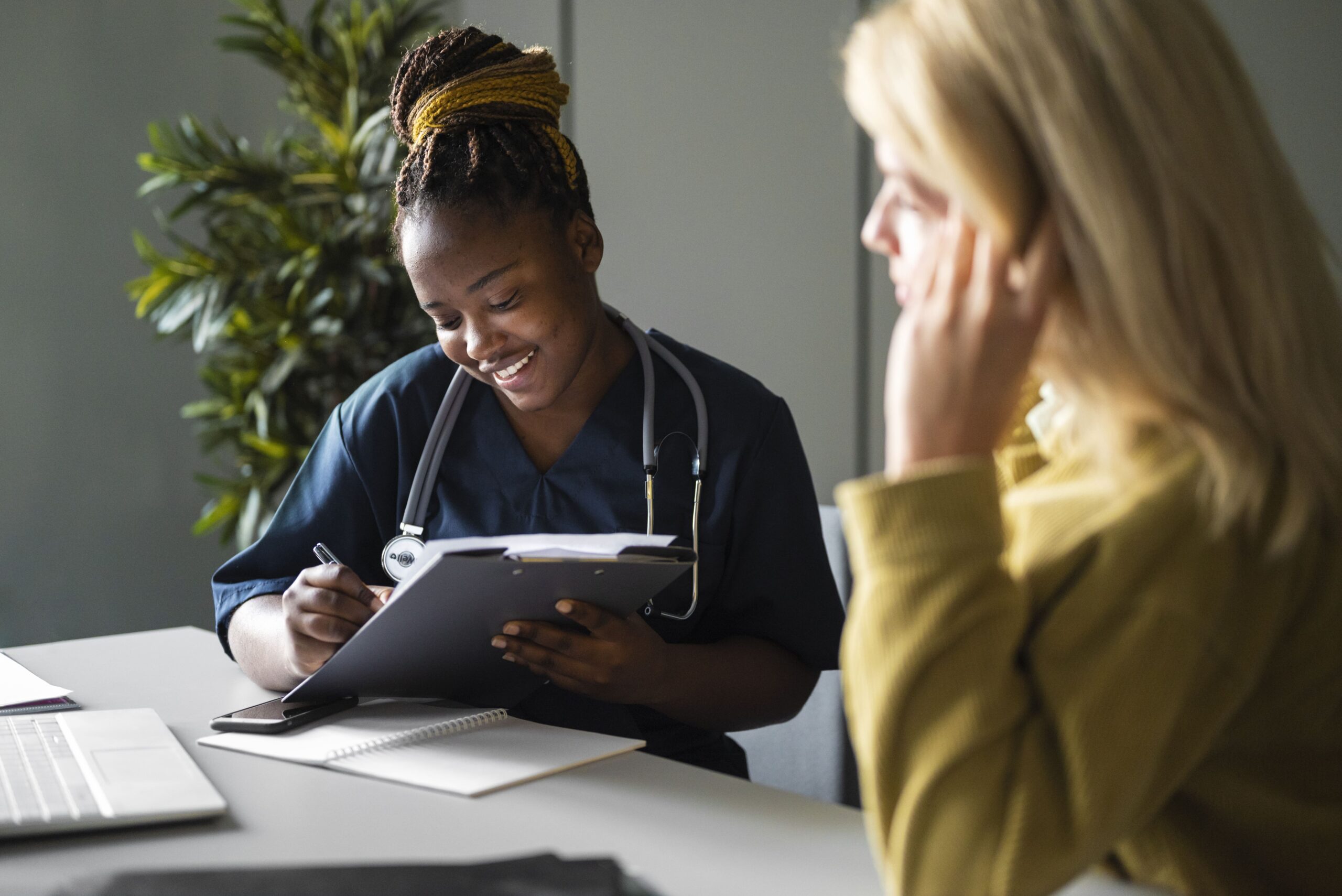 coronis health behavioral health working writing on clipboard with patient