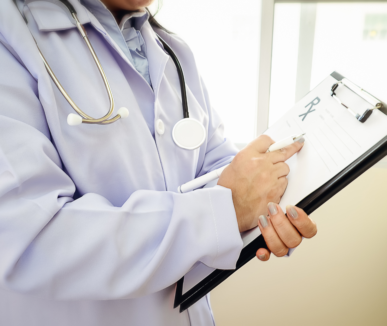 coronis health hospital medical worker referring to document on clipboard