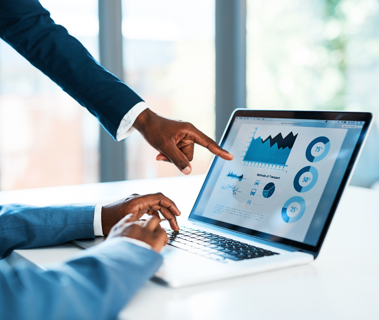 coronis health medical billers pointing to graph on laptop
