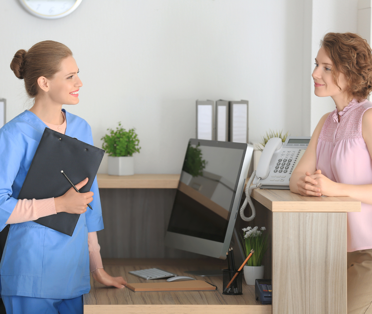 coronis health medical worker talking with patient at reception desk